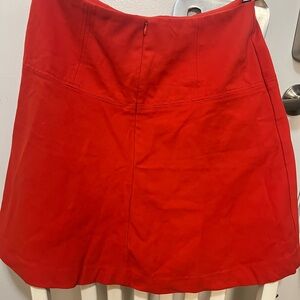 Mid length bright red fitted skirt.